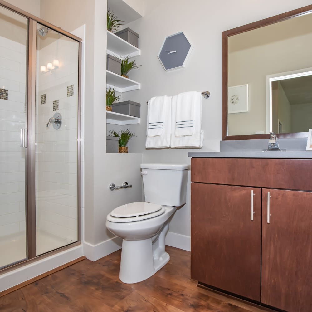 Spacious bathroom with sink, commode and glass shower at Park Place Olde Town Apartments in Arvada, Colorado