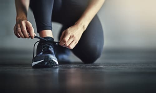 A person tying their athletic shoe at Palace Apartments in Concord, California