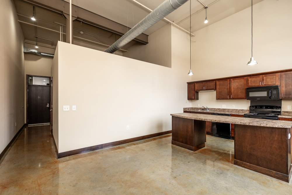 Kitchen area with dark cabinets and appliances at Rumely Lofts in Des Moines, Iowa