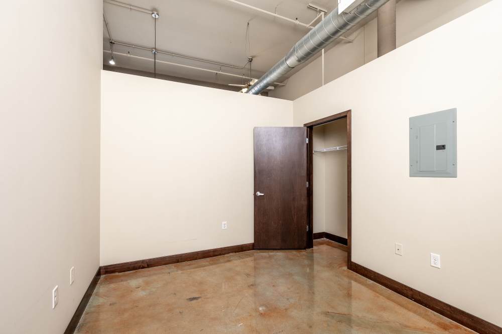Empty room with concrete floor and door at Rumely Lofts in Des Moines, Iowa
