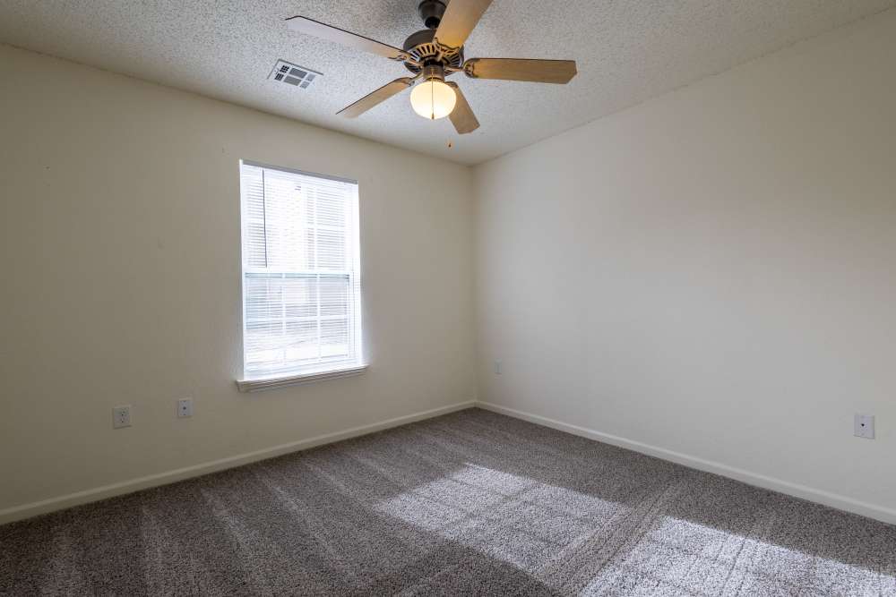 Spacious bedroom with soft carpeting and natural light at Adobe Ranch in Borger, Texas.
