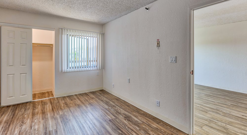 Kitchen and living room of an open floorplan apartment with wood-style plank flooring at The Springs in La Mesa, California