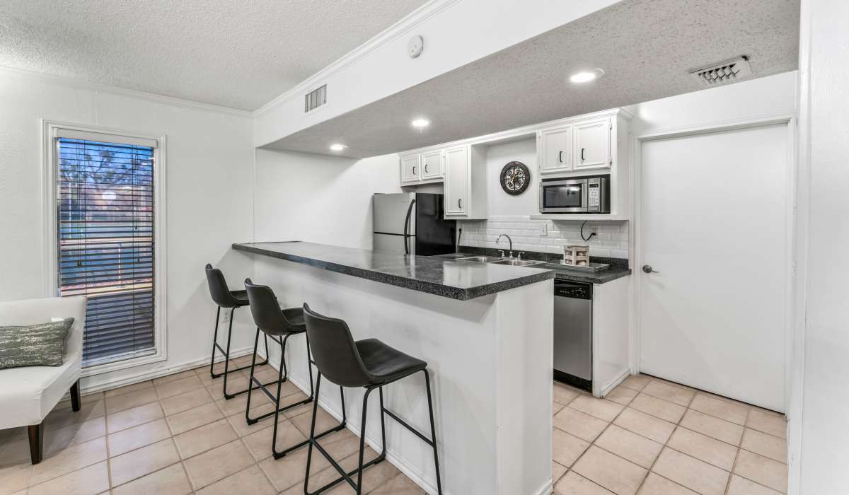 Clubhouse kitchen with white cabinets and bar seating at Riatta Ranch Apartments in Abilene, Texas