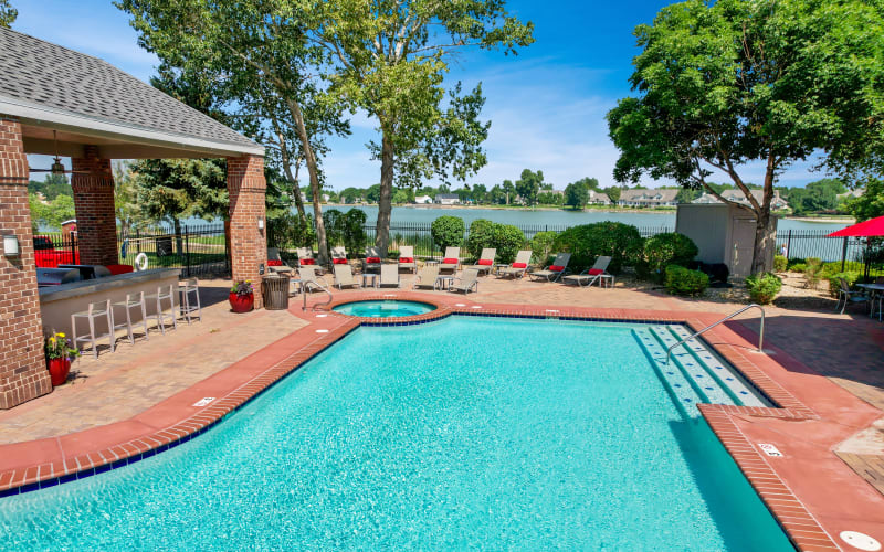 Large curved blue swimming pool at Promenade at Hunter's Glen Apartments in Thornton, Colorado