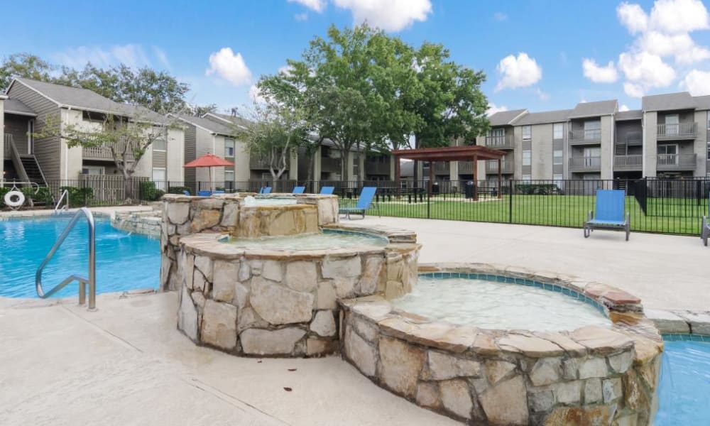 Adjacent spa with waterfall at outdoor pool at Circle at Point Park in Houston, Texas