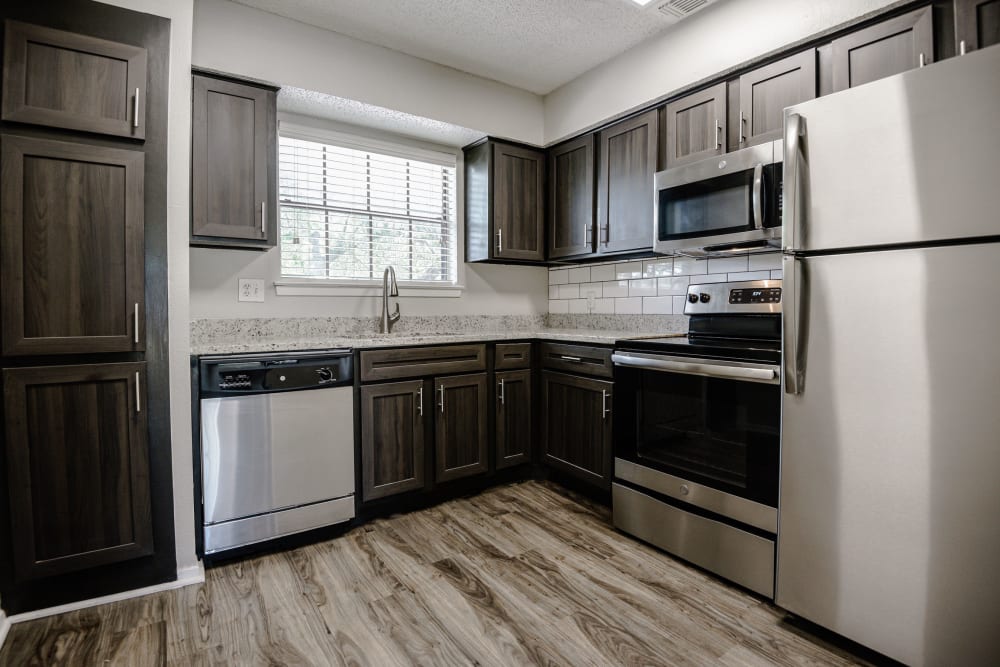 Modern kitchen with stainless steel appliances and granite countertops at The Regent in Dallas, Texas