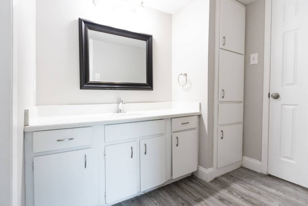 Sleek and modern bathroom vanity with stylish mirror and ample storage at San Mateo Forest in Dallas, Texas.