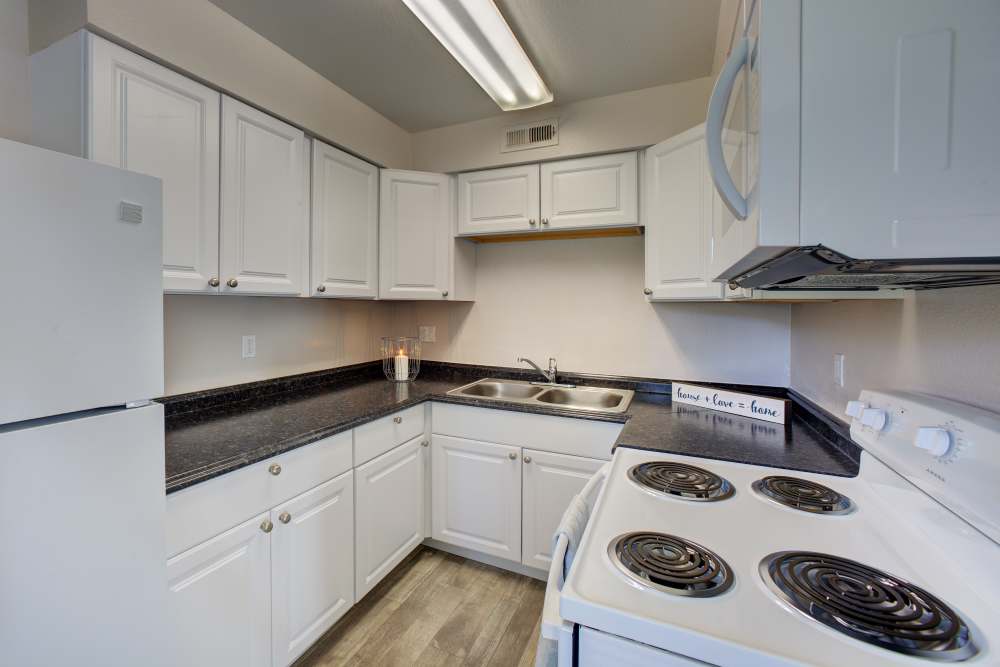 Kitchen with white appliances at Fair Oaks Apartments in Sacramento,California