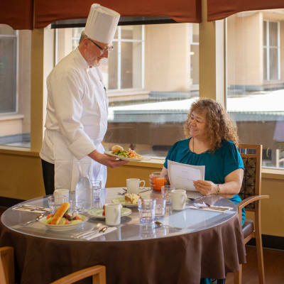 Chef presenting a freshly made meal to a resident at Peoples Senior Living in Tacoma, Washington