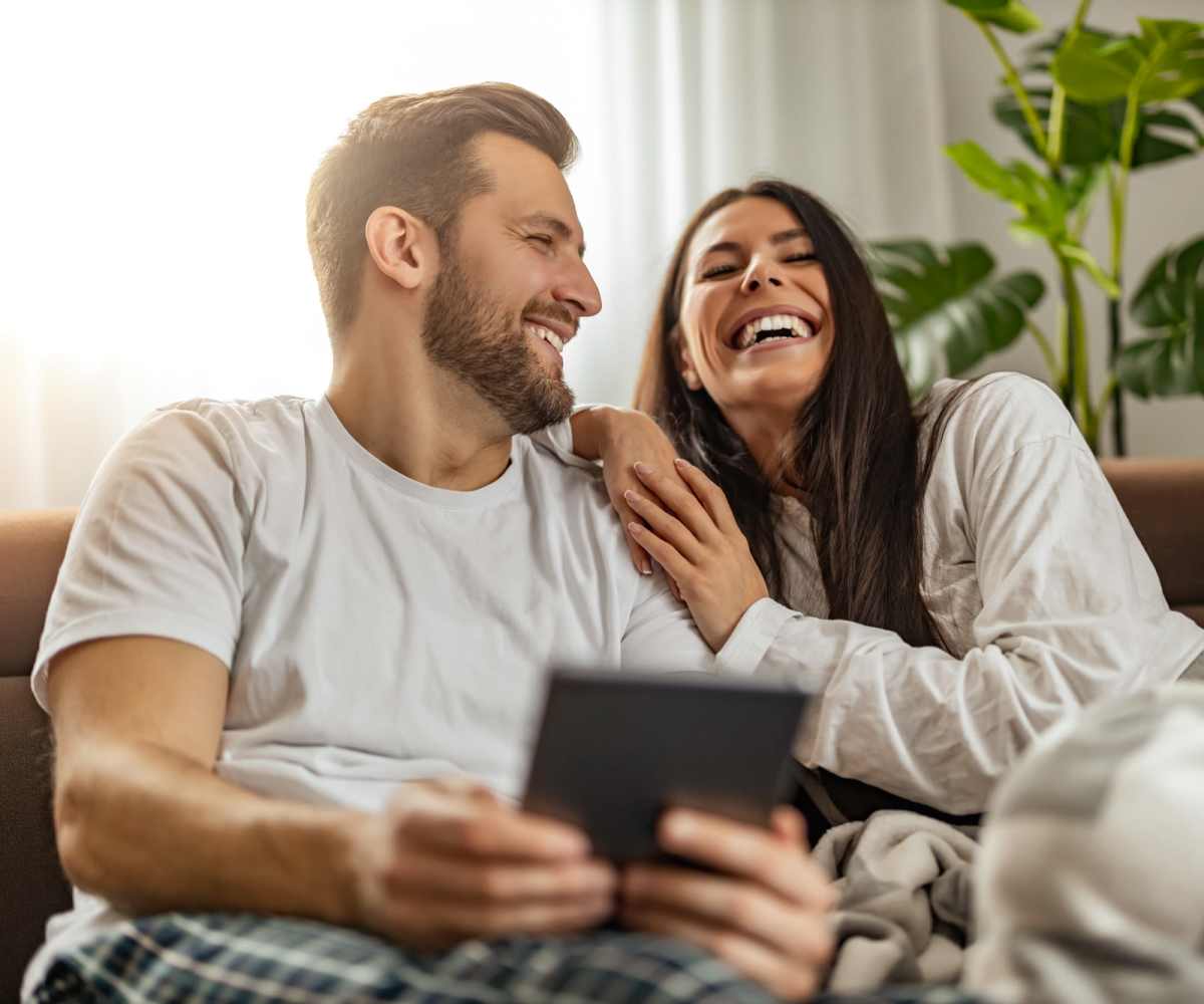 Living room with couple relaxing on couch at Autumn Ridge Apartments in Brooklyn Park, Minnesota