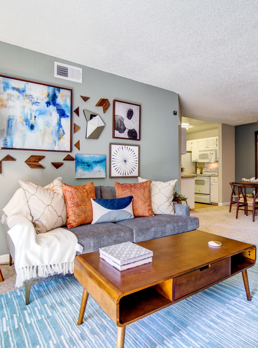 Retro-modern furnishings and an accent wall in a model home's living area at Waterstone Fremont in Fremont, California