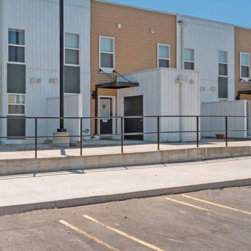 Modern apartment community with a gated entrance and accessible walkways at Winston Commons in Pontiac, Michigan