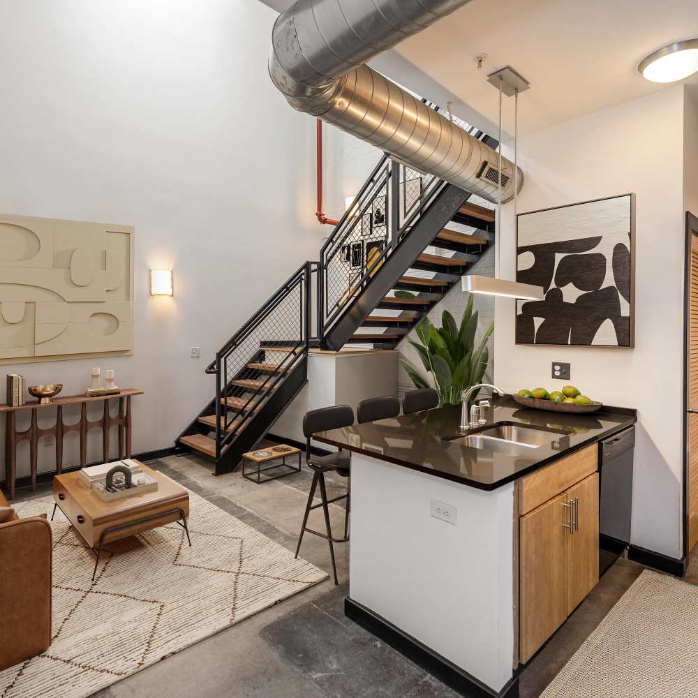 Modern apartment with a view of kitchen and staircase to the next level at Hopper Lofts in Richmond, Virginia