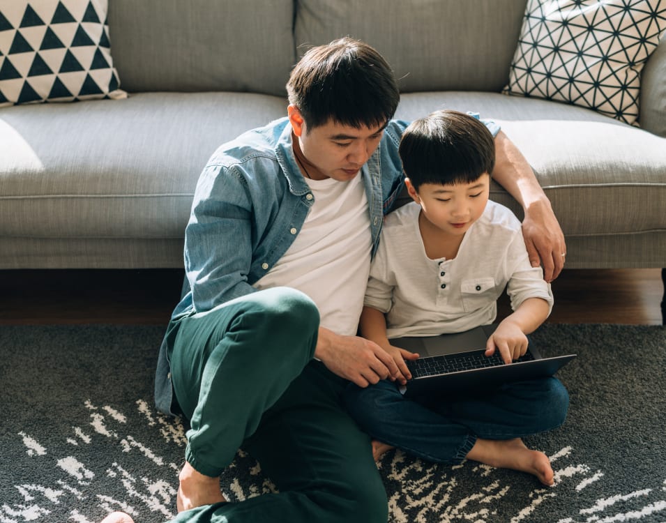 Resident student doing some homework on his laptop with help from his dad in their home at Vue Fremont in Fremont, California