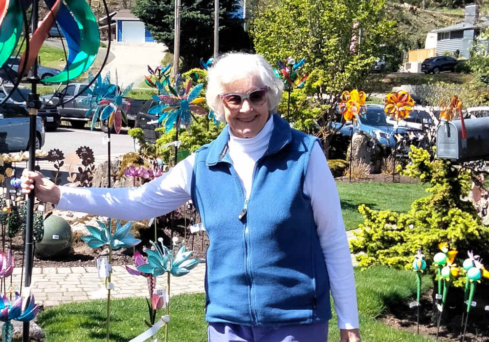 Resident posing next to garden art near Merrill Gardens at Tacoma in Tacoma, Washington