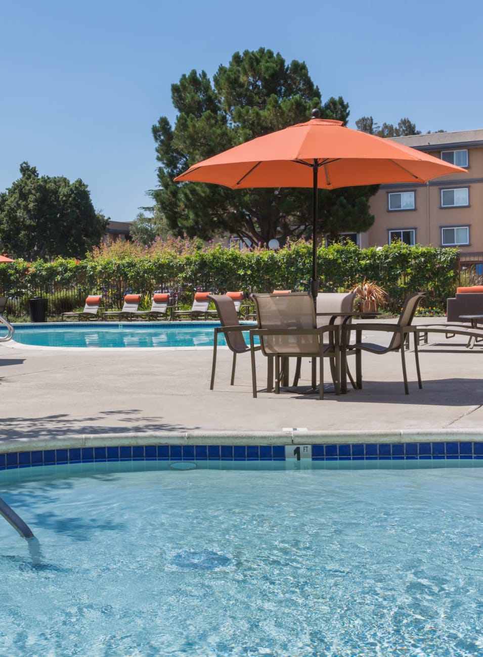 Children's wading pool with shaded tables and chairs nearby at Waterstone Fremont in Fremont, California