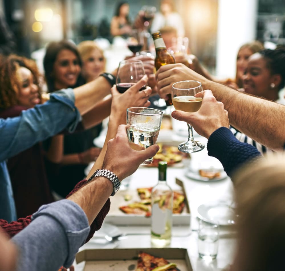 Group of resident friends out for a meal at their favorite restaurant and raising a toast to the good life at Skyline Terrace Apartments in Burlingame, California