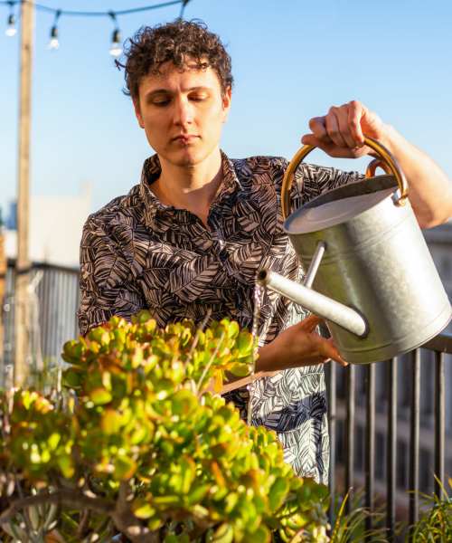 Resident watering plants at Sagewood Estates in Portland, Oregon