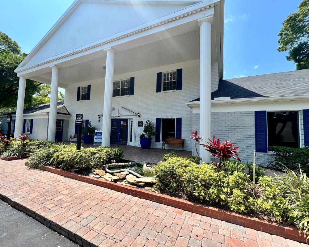 Exterior of the clubhouse with white columns and lush landscaping at Reserve at Lake Pointe Apartments & Townhomes in St Petersburg, Florida