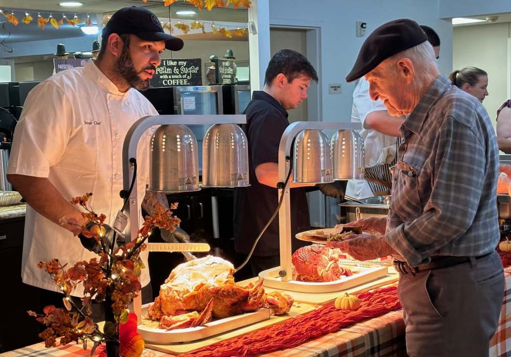 Resident getting food a buffet at Truewood by Merrill, Roseville in Roseville, California