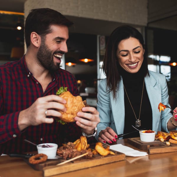 A couple laughing while eating at a restaurant near Chandler Residences in Roswell, Georgia