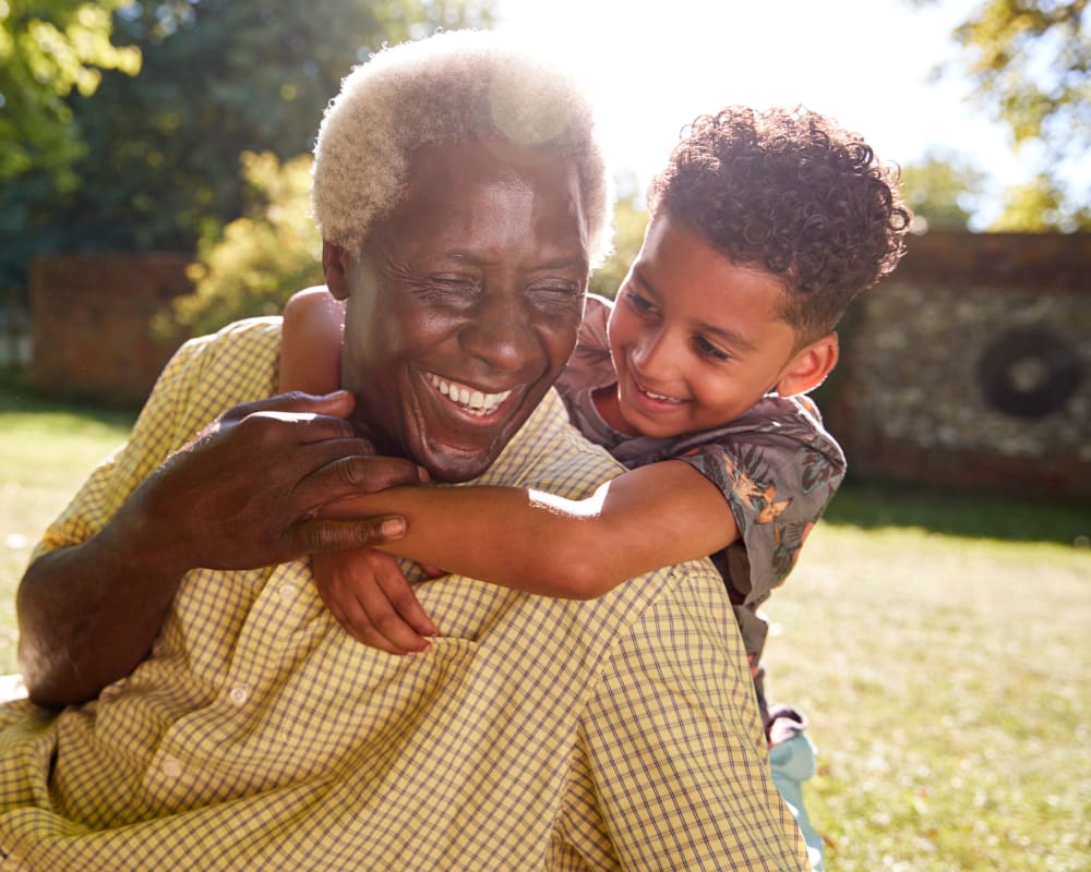 Resident plays with grandchild outdoors at Carrington Assisted Living in Green Bay, Wisconsin.
