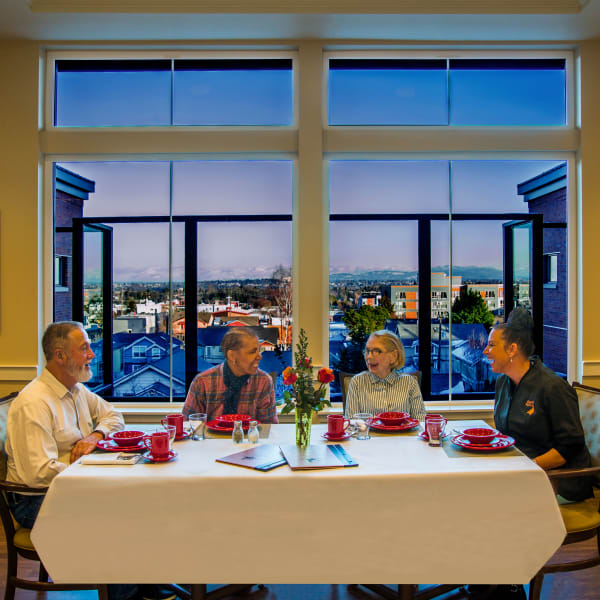 Residents sitting at a large dinner table at a Living Care Lifestyles community