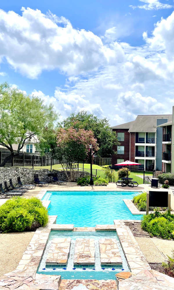 Swimming pool with lounge chairs at The Abbey at Medical Center in San Antonio, Texas
