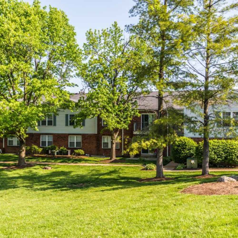 An apartments surrounded by lush greenery at Village Green Apartments in Chesterfield, Missouri