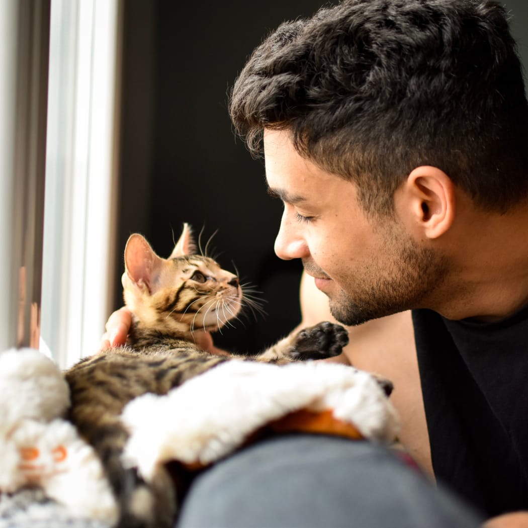 Resident looking at his cat at Bend at New Road Apartments in Waco, Texas
