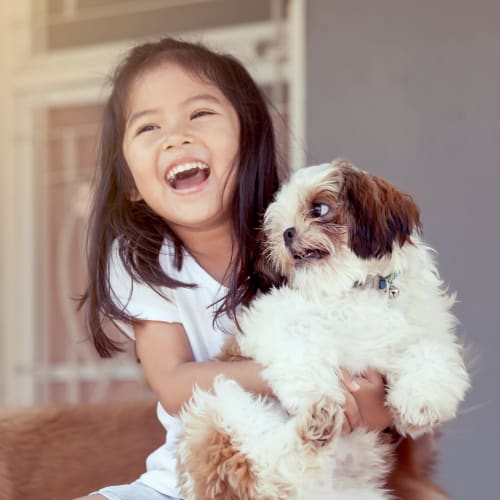 A child holding a small dog at The Village at Whitehurst Farm in Norfolk, Virginia