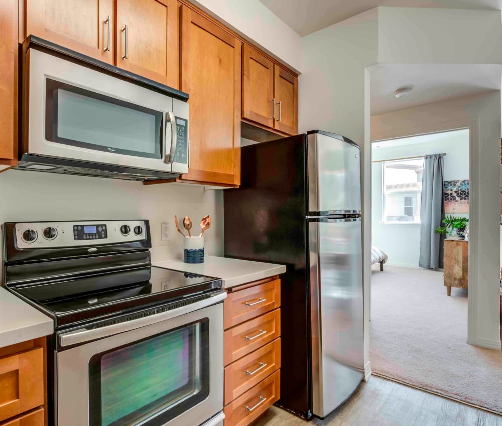 Modern kitchen with stainless-steel appliances and hardwood flooring in a model home at Sofi at Topanga Canyon in Chatsworth, California