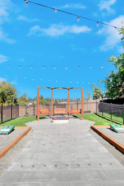 corn hole courts and outdoor fire-pit swing at Park South Apartments in Seattle