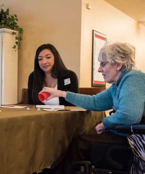 Resident and caregiver having a game night at The Springs at Willowcreek in Salem, Oregon