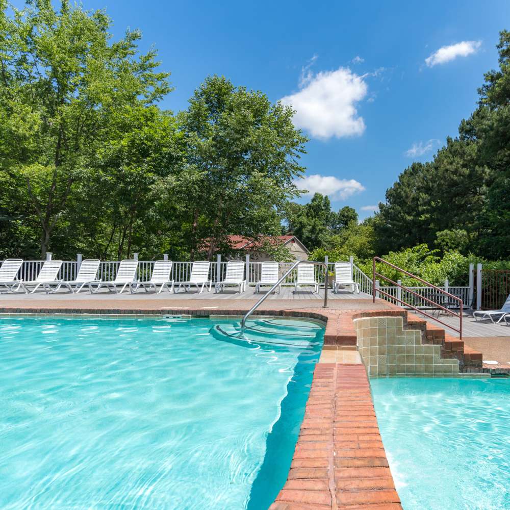 A swimming pool with a row of lounge beds at Park Canyon in Dalton, Georgia