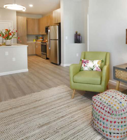 Sunlit living room with modern kitchen and cozy seating area at Messina Luxury Apartments in New Smyrna Beach, Florida