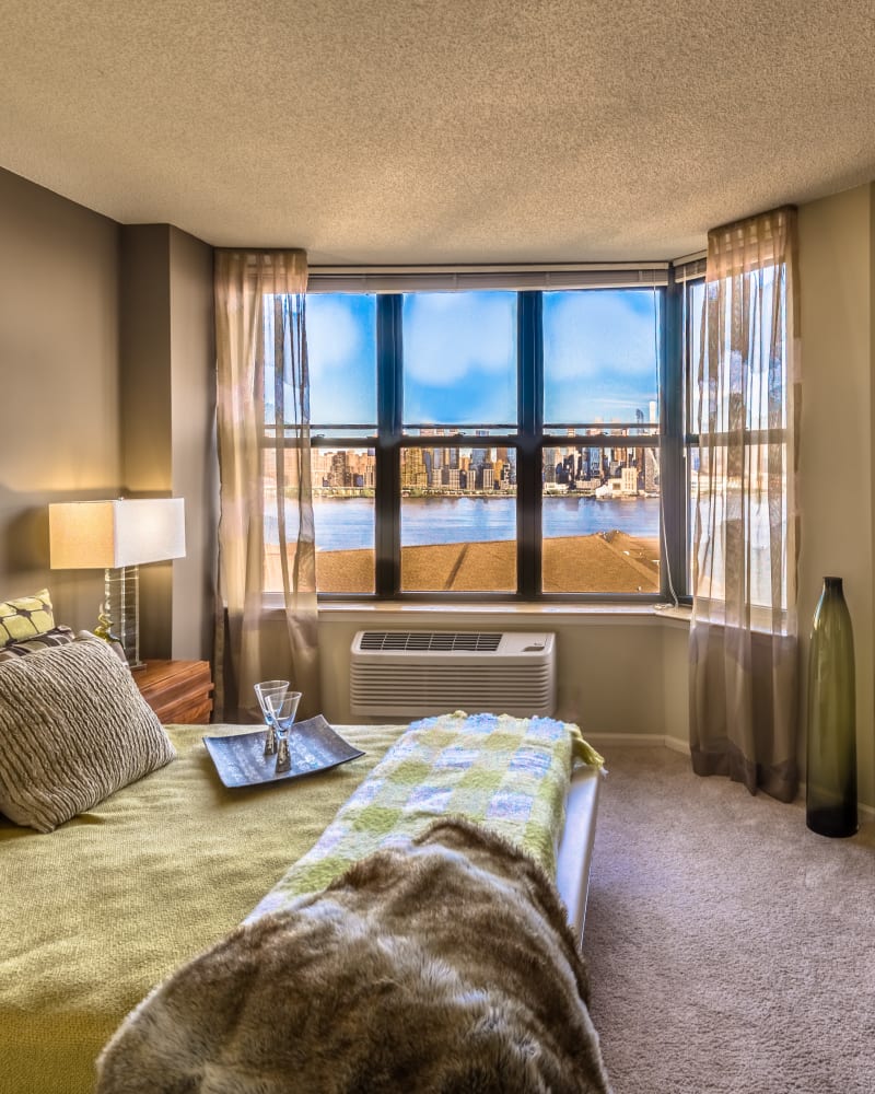 Model bedroom with large windows at Riverbend at Port Imperial in West New York, New Jersey