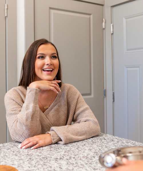 Resident seated at kitchen counter at The Flats at Crosspointe in Columbia, South Carolina