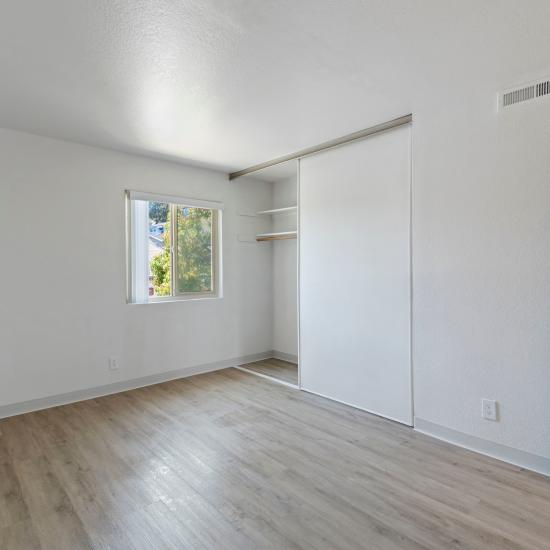 Bedroom with large window and closet at Mission Gardens in Santa Cruz, California