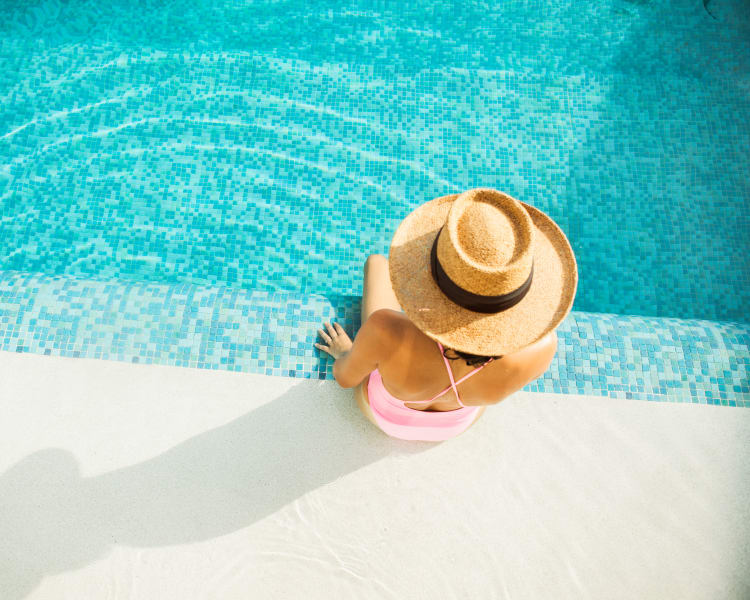 Resident relaxing poolside at Sofi Warner Center in Woodland Hills, California
