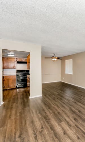 Spacious move-in ready apartment with hardwood style flooring at Franciscan Apartments in Garland, Texas