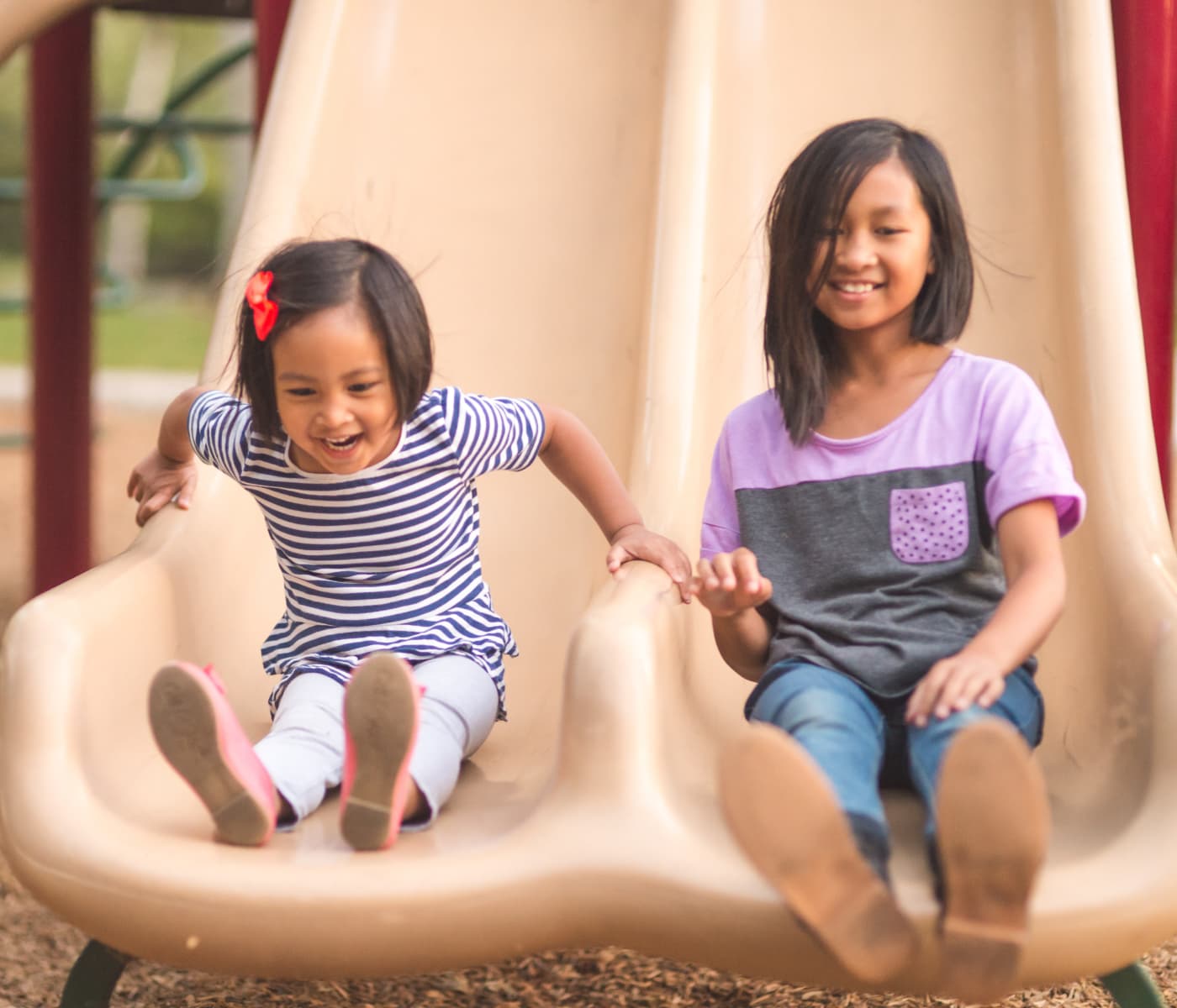 Little girls sliding at the park in Alexandria, Virginia near Mount Vernon Garden Apartments