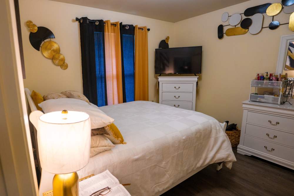 Cozy bedroom with a queen bed, decorative pillows, and a TV on the dresser at Willowbrook I in Lafayette, Louisiana