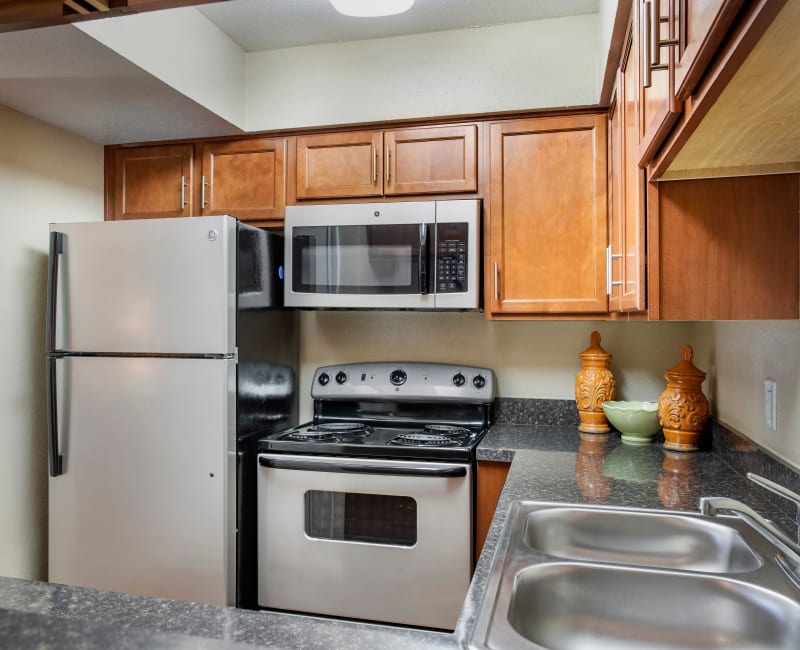 Fully equipped kitchen with built-in microwave and stainless steel appliances in a model home at Foundations at Austin Colony in Sugar Land, Texas