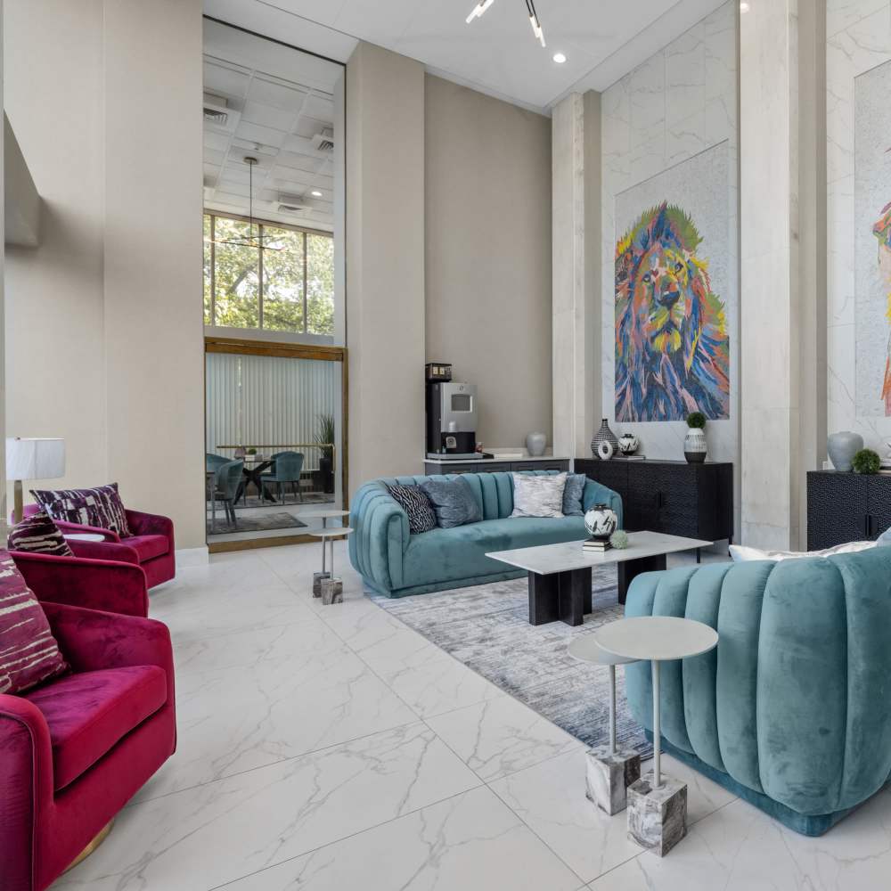 Charming lounge area featuring stylish turquoise sofas, modern artwork, and abundant natural light at The View at Forest Park in St. Louis, Missouri 
