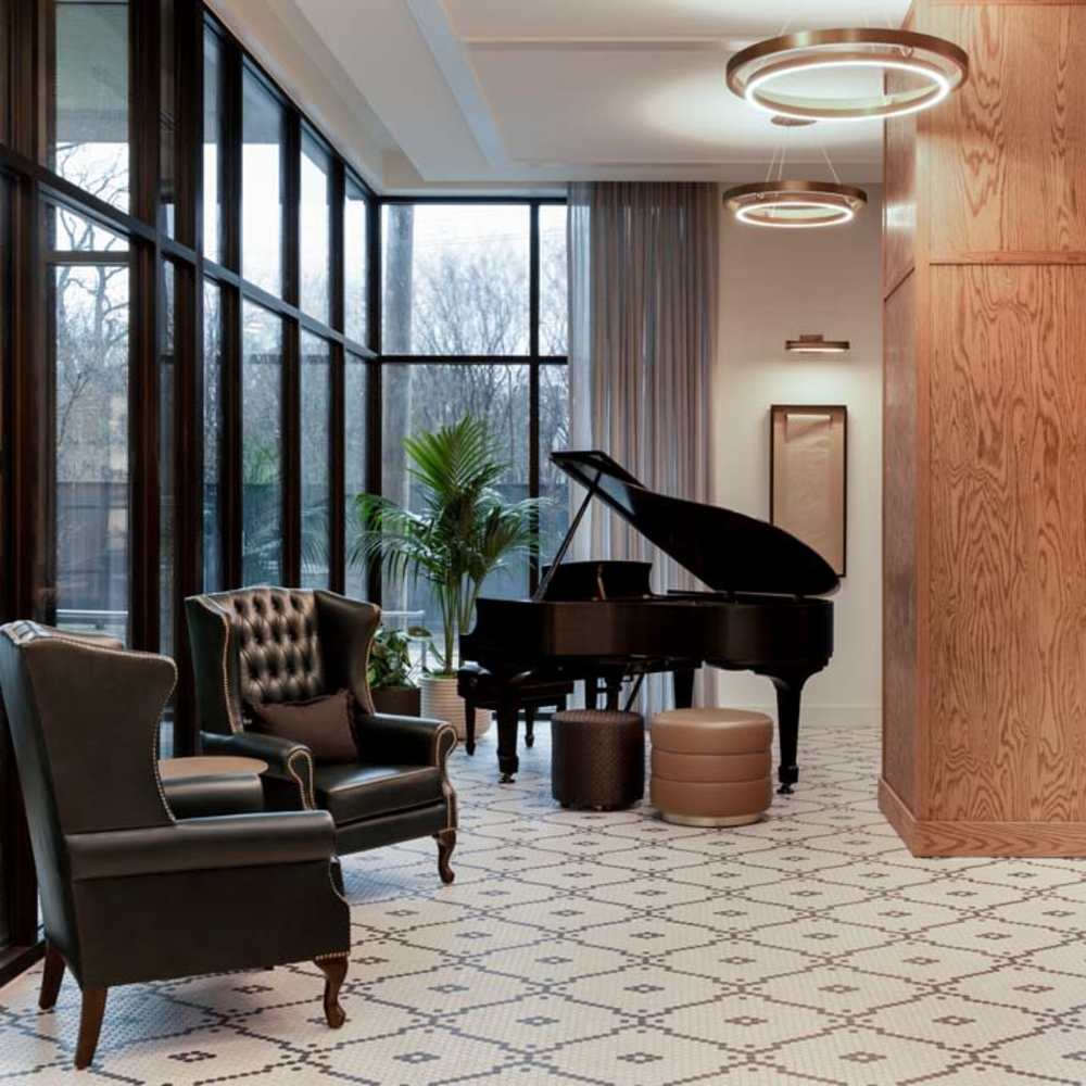 Clubhouse with wooden piano and seating area at Katy Trail Uptown in Dallas, Texas