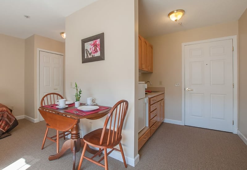 Bistro table and kitchen inside senior apartment at Randall Residence of Troy in Troy, Ohio