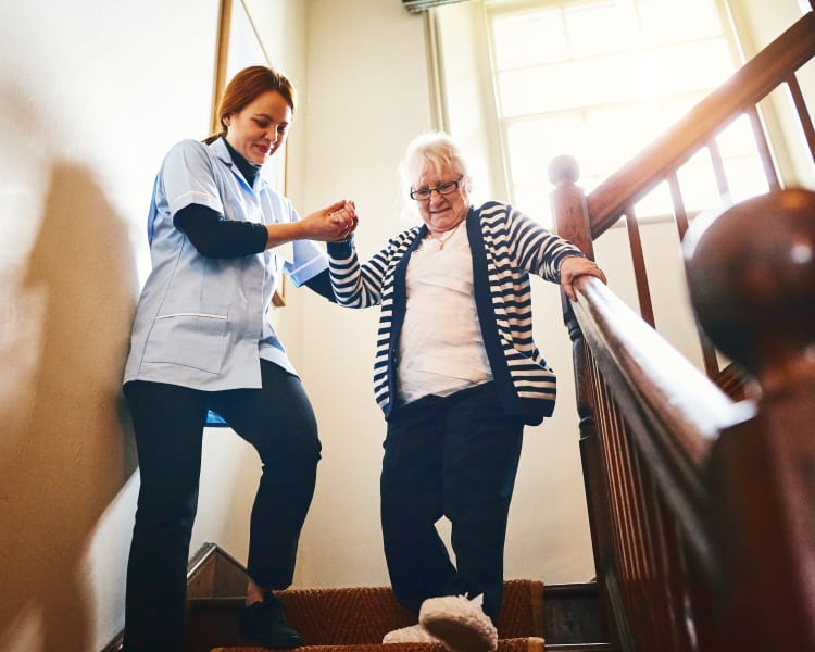 A caregiver assisting a resident down the stairs at Harmony Senior Services in Charleston, South Carolina