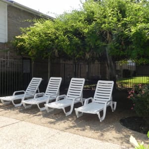 Shaded lounge chairs at the pool at Highlands of Grand Prairie in Grand Prairie, Texas