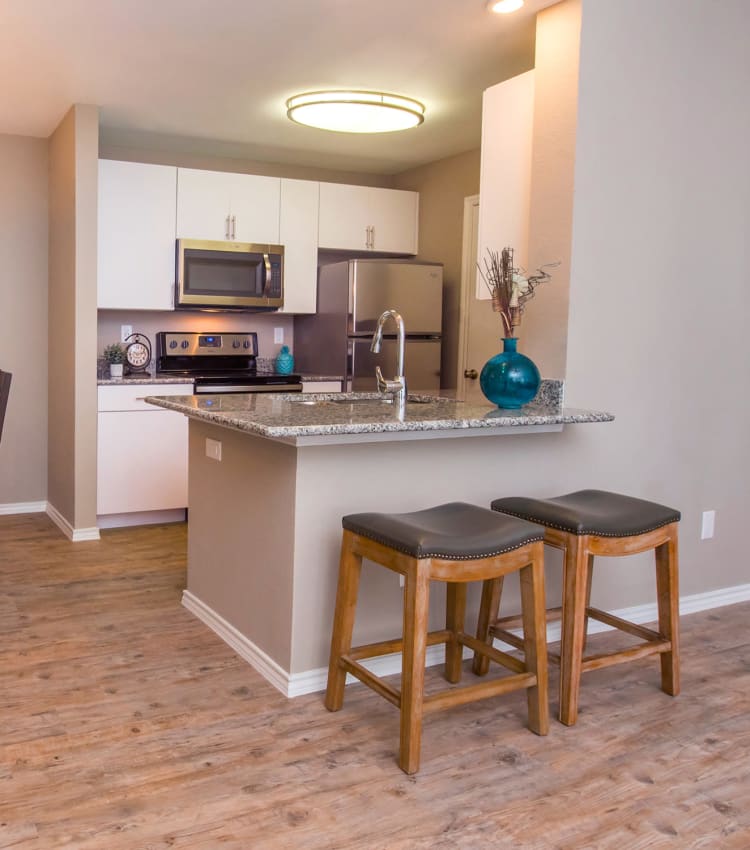 Granite countertops and wood floor in a kitchen at Carrollton Park of North Dallas in Dallas, Texas
